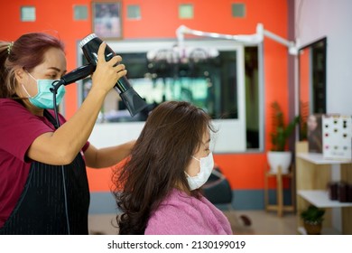 Asian Young Woman Have A Hair Cutting And Spa By Professional Beauty Hair Dresser. Woman Sitting On The Chair In Beauty - Salon Shop While Barber Cutting Her Hair.