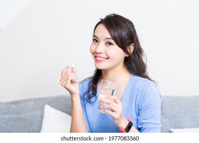 Asian Young Woman Holding A Glass Of Water With Vitamin Has Healthy Life And She Smile At You