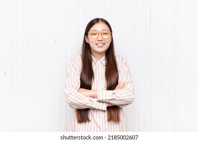 Asian Young Woman Laughing Happily With Arms Crossed, With A Relaxed, Positive And Satisfied Pose