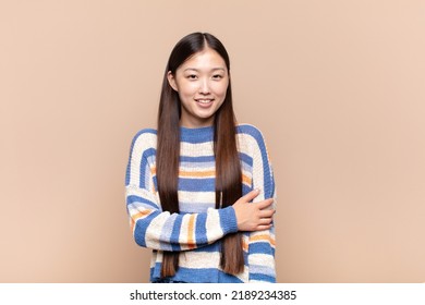 Asian Young Woman Laughing Shyly And Cheerfully, With A Friendly And Positive But Insecure Attitude