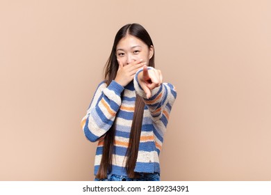 Asian Young Woman Laughing At You, Pointing To Camera And Making Fun Of Or Mocking You