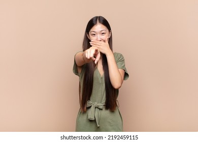 Asian Young Woman Laughing At You, Pointing To Camera And Making Fun Of Or Mocking You