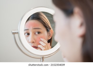 Asian Young Woman Looking Face Skin In The Mirror Have A Red Rash On Her Face From Cosmetic Allergy