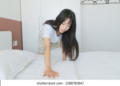 Asian Young Woman Making Bed In Bedroom