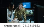 Asian young woman, military office worker, and Caucasian female soldier studying maps and plans of conflict zone in monitoring room. Army strategy planning and troops dislocation concept.