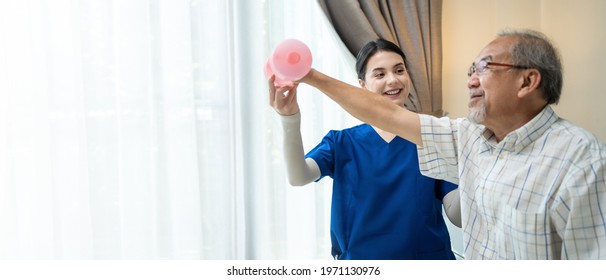 Asian Young Woman Nurse At Home Nursing Care Support Disabled Senior Elderly Man. Caregiver Therapist Serve Physical Therapy For Older Patient Exercise With Dumbbell. Physiotherapist Insurance Concept