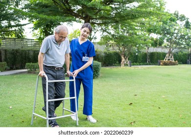 Asian young woman nurse at nursing home take care disabled senior man. Caregiver doctor serve physical therapy for older elderly patient to exercise and practice walking on walker or cane at backyard.