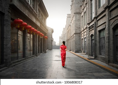 Asian Young Woman In Old Traditional Chinese Dresses In Hutong Village In Beijing, China. Woman Walking To Sight Seeing In Beijing.