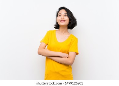 Asian Young Woman Over Isolated White Background Looking Up While Smiling