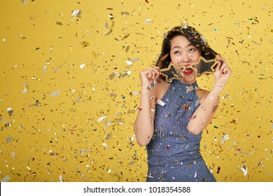 Asian Young Woman With Party Glasses Standing Under Falling Confetti