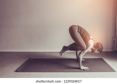 Asian young woman practicing yoga in  gray background.Young people do yoga indoor.
