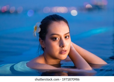 Asian Young Woman Relax In Swimming Pool At Luxury Hotel Spa Enjoying Beautiful .Close Up Female Enjoying Summer Travel In City Hotel. Vacation Woman In Bikini .