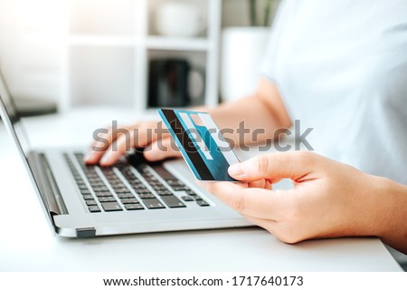 Asian young woman resting and browsing internet with Laptop holding credit card online shopping concept