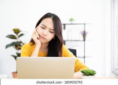 Asian young woman seriously working on computer laptop in house. She thinking find solution problem of work - Powered by Shutterstock