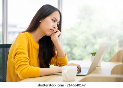 Asian Young Woman Seriously Working On Computer Laptop In House. She Thinking Find Solution Problem Of Work