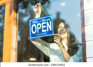 Asian Young Asian Woman Setting Open Sign At The Shop Glasses For Welcome The Customer In To The Coffee Shop, Small Business Owner And Startup With Cafe Shop, Installing Open And Close Label Concept