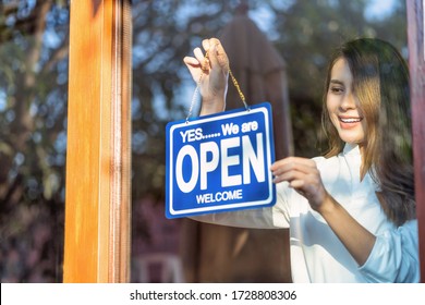 Asian Young Asian Woman Setting Open Sign At The Shop Glasses For Welcome The Customer In To The Coffee Shop, Small Business Owner And Startup With Cafe Shop, Installing Open And Close Label Concept