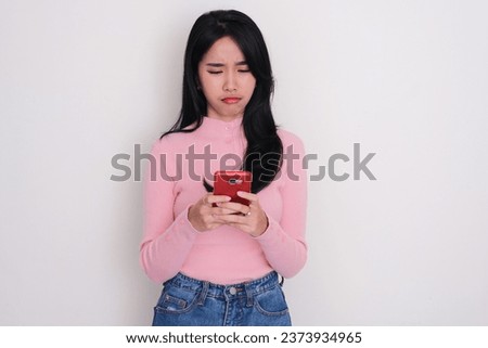 Asian young woman showing sad expression when typing on her phone