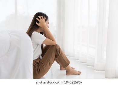 Asian young woman sitting looking at window with stress and Anxiety, headache at home. Concept Mental Health - Shutterstock ID 1945215967