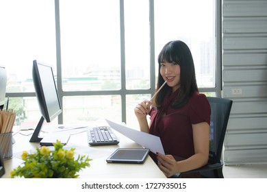 Asian Young Woman Smiled, Looking At The Report Of Orders With Great Satisfaction In Her Office, Startup And Bussiness Owner