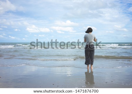 Asian young woman standing facing the sea. Feeling really lonely, heartbroken sea like a nursery of clearing the mind. The concept of liberation travel alone.
