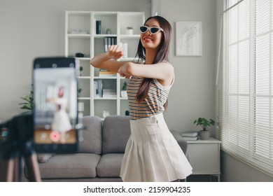 Asian young woman tiktoker created her dancing video by smartphone camera. To share video on social media application - Shutterstock ID 2159904235