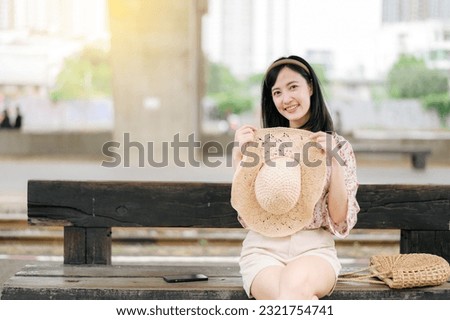 asian young woman traveler with weaving basket waiting for train in train station. Journey trip lifestyle, world travel explorer or Asia summer tourism concept.