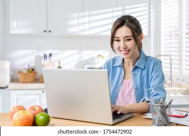 Asian Young Woman Use Laptop To Work At Home