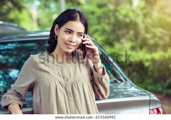 Asian young woman\
using mobile phone calling mechanic car service ,auto engine crash\
with alone woman concept.