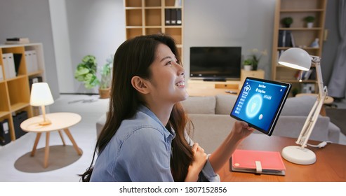 Asian Young Woman Using Smart Home App To Control Light Turning On With Tablet Pc