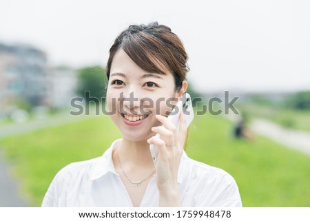 Asian young woman using a smartphone to call with a smile