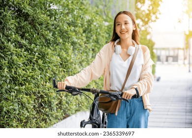 Asian young woman walking alongside with bicycle on summer in park countryside outdoor, Happy female smiling walk down the street with her bike on city road, ECO environment, healthy holiday travel - Shutterstock ID 2365339697
