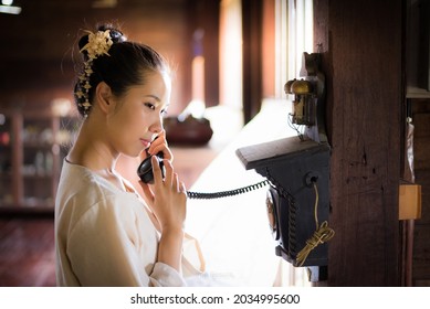 Asian Young Woman Wearing Traditional Thai Culture Lanna Dress Vintage Style Using An Old Phone, Kasalong Chaingmai Thailand