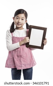 A Asian(korean, Japanese, Chinese) Girl(kid, Student, Child, Woman, Female) Wearing Pink Skirt And Denim Pants Stand Up With A Wood Photo Frame For Friend And Family Isolated White.