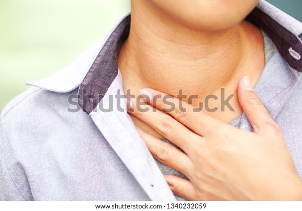 Asians wear blue shirt have abnormal of thyroid\
gland at the right throat (Hyperthyroidism, Overactive Thyroid) :\
Health, illness and medical\
concept.