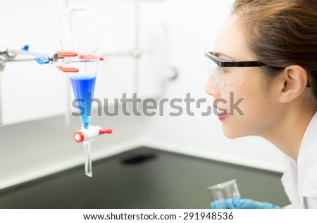 Asiatic Researcher looks at a Funnel in an Organic Chemistry Lab
