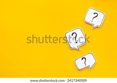 Ask and answer concept. Question marks on speech bubbles, top view.