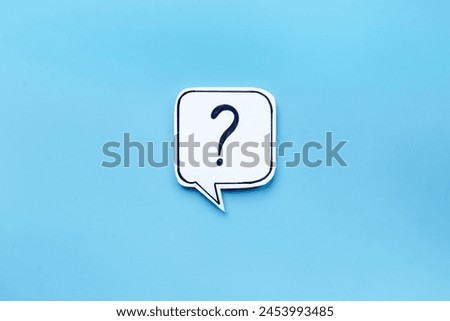 Ask concept. Question mark on paper speech bubble, top view.