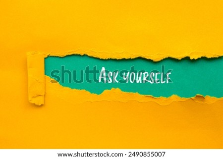 Ask yourself message written on ripped torn yellow paper with blue background. Conceptual ask yourself symbol. Copy space.