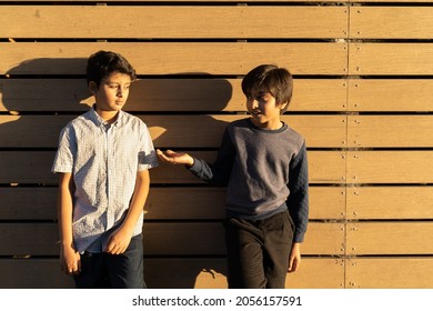 Asking For Help. Two Young Boys Friendship Concept. South Asian Kid Extending Hand. Golden Hour Casual Scene Of Children.