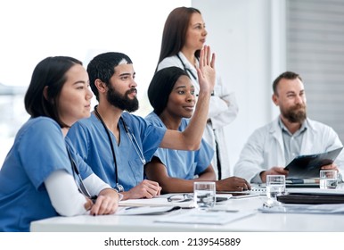 Asking Probing Questions About The Problem. Shot Of A Doctor Raising His Hand During A Meeting In A Hospital Boardroom.