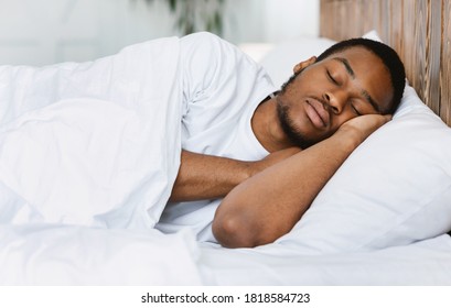 Asleep African American Guy Sleeping Resting Peacefully In His Comfortable Bed At Home, Lying With Eyes Closed. Recreation, Deep Male Sleep, Time To Rest And Nap Concept.