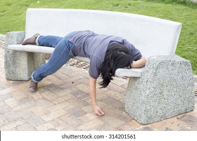 Asleep or drunk woman outdoors on a park bench