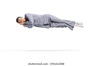 Asleep man in pajamas floating in the air isolated on white background