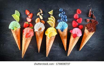 Asorted of ice cream scoops with cones in row on black background. Colorful set of ice cream scoops of different flavours. Sweet icecream like chocolate, lemon, lime, almond, strawberries, vanilla.