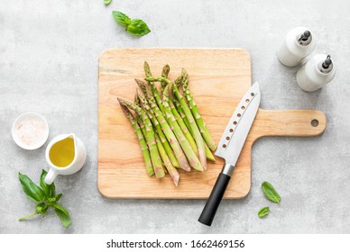 Asparagus cooking concept, top down view on a cutting board with fresh bunch of asparagus, lying down on a kitchen table, spring healthy cooking idea