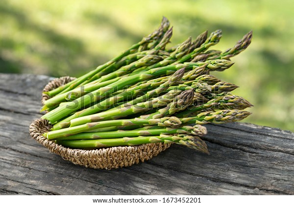 Asparagus. Fresh\
Asparagus. Pickled Green Asparagus. Bunches of green asparagus in\
basket, top view-\
Image
