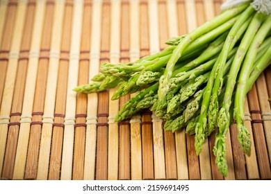 Asparagus is green and straight vegetable. Fresh, green asparagus is crispy for cook on wood table.