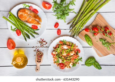 Asparagus, Salmon Fish, Farro Salad And Other Healthy Food On White Wooden Table