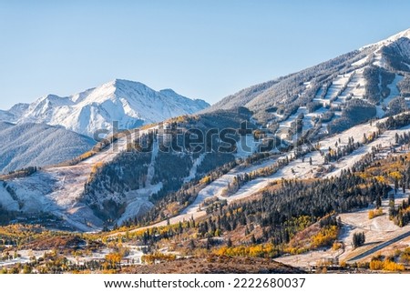 Aspen, Colorado buttermilk ski resort town slopes hill in Rocky mountains view on sunny day with winter snow on yellow foliage autumn trees